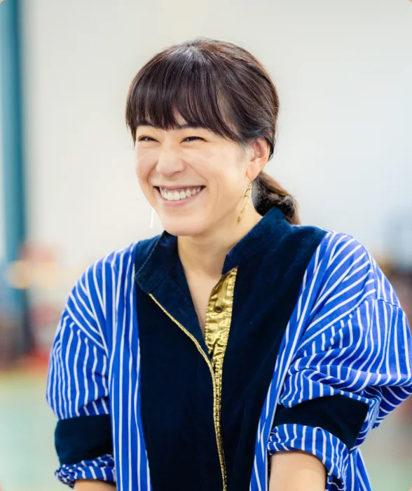ストライプのシャツで笑顔の女性スタッフ