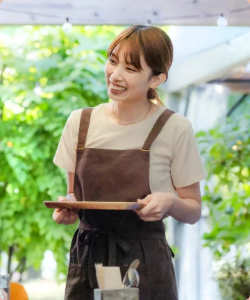 トレイを手に微笑むカフェスタッフ